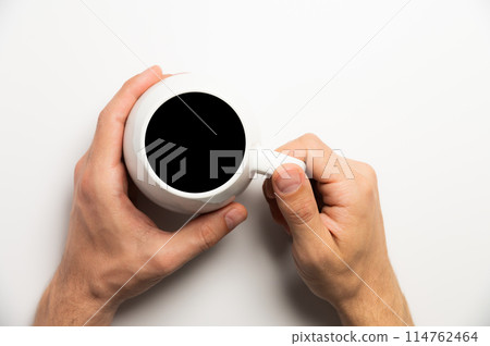 Hand holds a cup of hot chocolate cocoa drink on a white background. View from above. Flat layout Hand holds a cup of hot chocolate cocoa drink on a white background. View from above. Flat layout 114762464