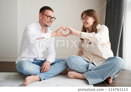 Young father and his daughter making heart symbol by hands. Lovely spending time with family. Cute moment of kid and dad showing their love to each other. 114763113