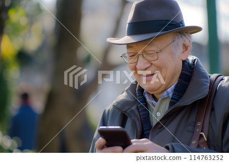 Senior man operating a smartphone with a smile 114763252