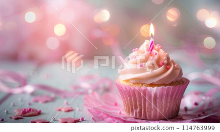 pink cake with candle on blurred shiny background 114763999