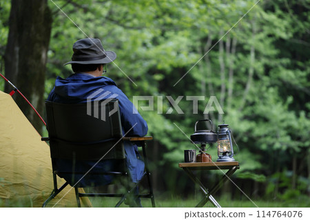 Man enjoying camping at sunset Man enjoying camping at sunset 114764076