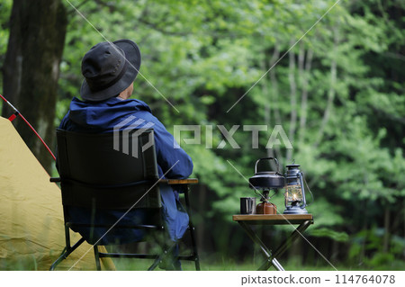 Man enjoying camping at sunset Man enjoying camping at sunset 114764078