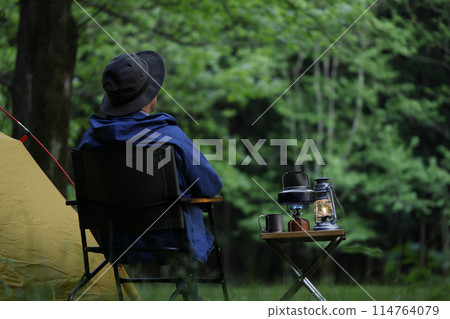 Man enjoying camping at sunset Man enjoying camping at sunset 114764079