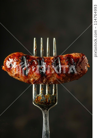 Close-up of a Grilled Sausage on a Fork against a Dark Background Close-up of a Grilled Sausage on a Fork against a Dark Background 114764993