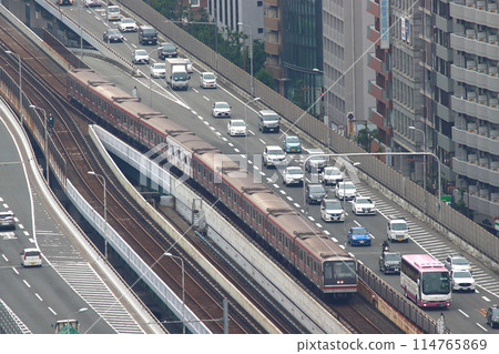 A night bus and Osaka Metro Midosuji Line 21 series train on the Shin-Midosuji street during the morning rush hour A night bus and Osaka Metro Midosuji Line 21 series train on the Shin-Midosuji street during the morning rush hour 114765869