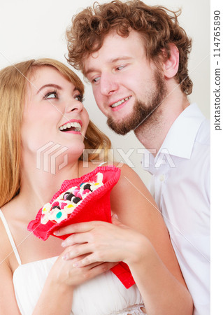 Loving couple with candy bunch flowers. Love. 114765890