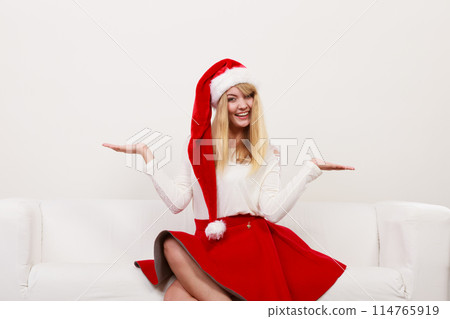 Woman in santa hat with empty hands for copy space Woman in santa hat with empty hands for copy space 114765919