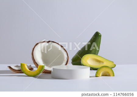 White background photo of avocado and coconut theme, blank pedestal in center for showing product extracted from natural ingredient. Blank space for design with frontal shot 114766056