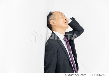 Middle-aged man, business, leaning against wall 114766780