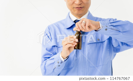 一個穿著工作服、能量飲料的男人 114767067