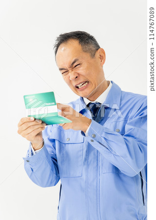 穿著工作服的男人哀嘆銀行存摺垂直 114767089
