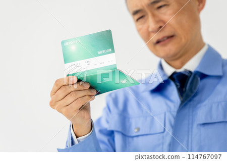 一個穿著工作服的男人特寫地感嘆他的銀行存摺 114767097