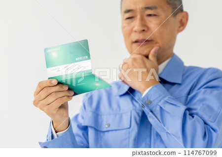 Man in work clothes, bankbook, lament, close-up 114767099