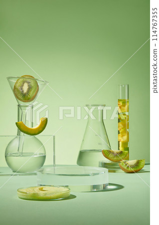An empty podium in round shaped arranged with laboratory glassware containing avocados and kiwis. Experiment with the tools of modern technology close-up factory research study 114767355