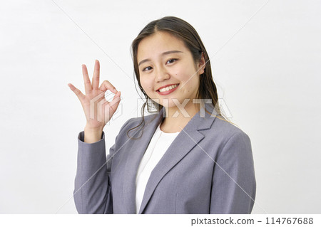 年輕女商人給出 OK 手勢，白色背景 114767688