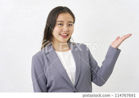 年輕女商人用手掌、白色背景指著右邊 114767691