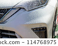 Wash your car by spraying foam with a pressure-type foam gun 114768975