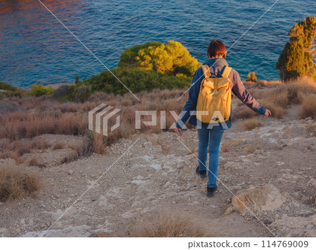 Young woman hiking on rocky beach in Spain, Benidorm 114769009