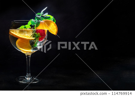 Fancy cocktail with fresh fruit. Gin and tonic drink with ice at a party Fancy cocktail with fresh fruit. Gin and tonic drink with ice at a party 114769914