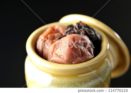 黑色背景下罐子裡的醃李子和紅紫蘇的照片 114770220