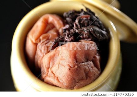 黑色背景下罐子裡的醃李子和紅紫甦的鳥瞰圖。 114770330