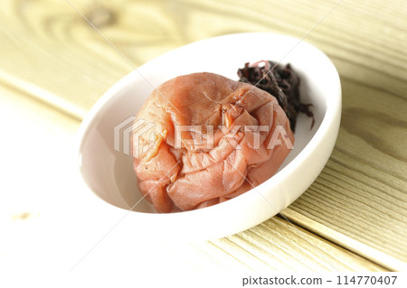 Red shiso and pickled plums served on a small plate 114770407
