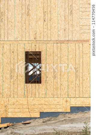 An ongoing construction site in the suburbs, featuring the framing stage of a single-family house. An ongoing construction site in the suburbs, featuring the framing stage of a single-family house. 114770456