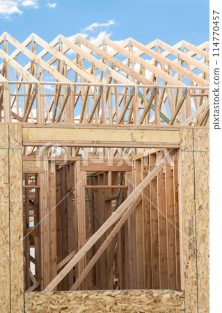 An ongoing construction site in the suburbs, featuring the framing stage of a single-family house. An ongoing construction site in the suburbs, featuring the framing stage of a single-family house. 114770457