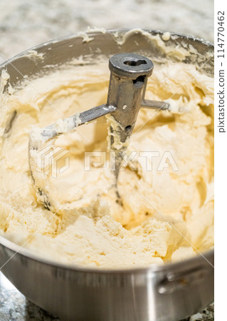 Stand mixer whips up creamy buttercream frosting to perfection, ready for dessert decorating. Stand mixer whips up creamy buttercream frosting to perfection, ready for dessert decorating. 114770462