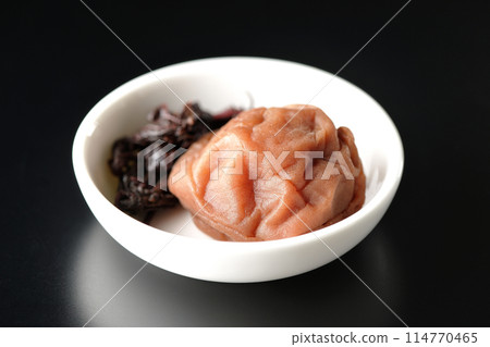 黑色背景下小盤子上的紅紫蘇和醃李子的照片 黑色背景下小盤子上的紅紫蘇和醃李子的照片 114770465