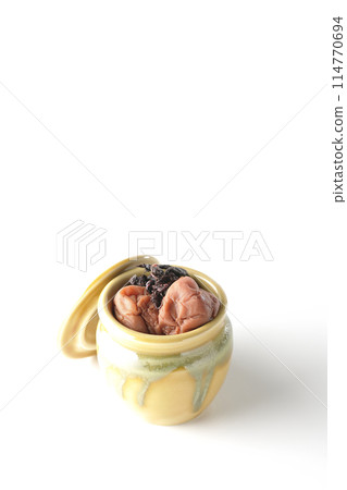 Pickled plums and red shiso in a jar photographed on a white background Pickled plums and red shiso in a jar photographed on a white background 114770694