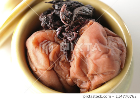 Aerial view of pickled plums and red shiso in a jar on a white background Aerial view of pickled plums and red shiso in a jar on a white background 114770762