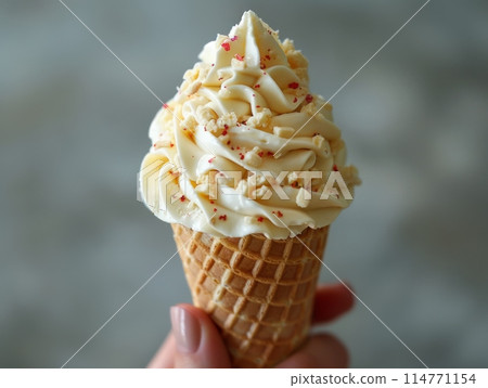 Ice cream in a cone that melts in the hand. 114771154
