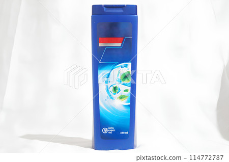 A blue bottle of shampoo with a blue cap 114772787