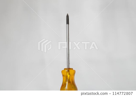 A yellow screwdriver with a silver tip A yellow screwdriver with a silver tip 114772807