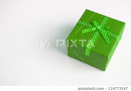 Green present on white background with customizable space for text. Copy space and celebration. 114773247