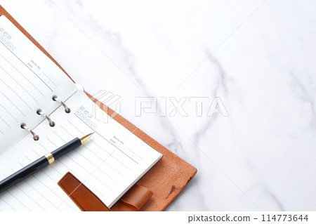 Image of a ring-type system organizer open while doing desk work Image of a ring-type system organizer open while doing desk work 114773644