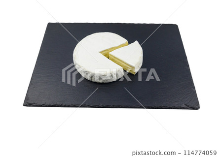 Piece of brie cheese on black slate board isolated on white background 114774059