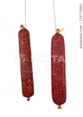 Two hanging raw smoked sausage isolated on white background Two hanging raw smoked sausage isolated on white background 114774063