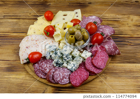 Antipasti platter with olives, cherry tomatoes, assortment of italian salami and cheese on a wooden table Antipasti platter with olives, cherry tomatoes, assortment of italian salami and cheese on a wooden table 114774094