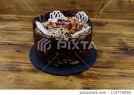 Tasty chocolate cake on a wooden table Tasty chocolate cake on a wooden table 114774099