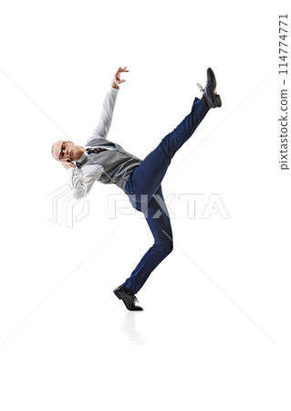 Young businessman in formal attire, balancing on one leg and having call against white studio background. 114774771