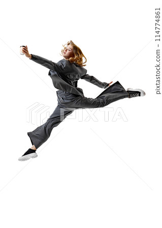 Young woman in smart casual attire leaping in mid-air and reaching hand to coffee against white studio background. 114774861