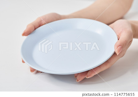 Woman's hand holding an empty plate Woman's hand holding an empty plate 114775655