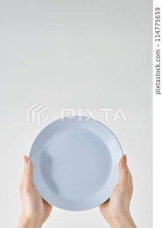 Woman's hand holding an empty plate 114775659