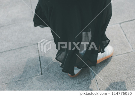 Woman walking on block sidewalk 114776050