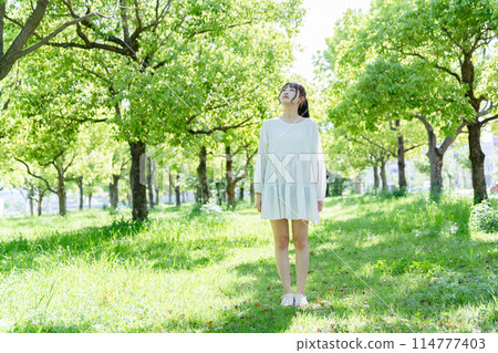 A woman walking in the park 114777403