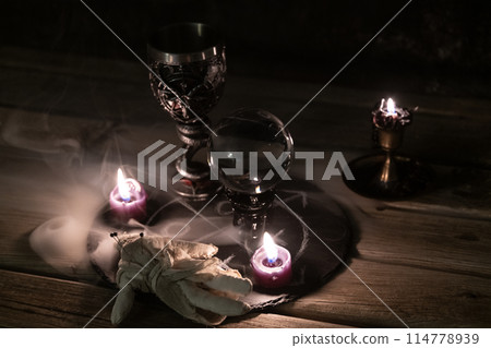 Mysterious Occult Ritual Setup with Crystal Ball and Candles. 114778939