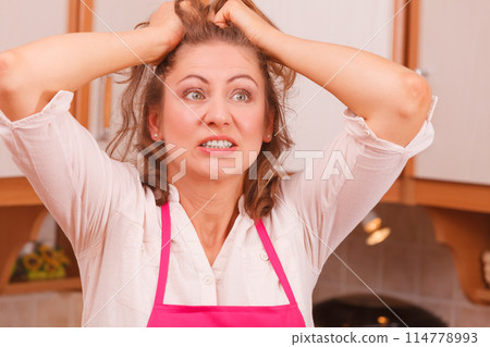 Unhappy housewife in kitchen 114778993