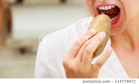 Woman eating potato. Woman eating potato. 114779072
